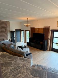a living room with a large couch in a room with a television at Haven Fortress in Kalven