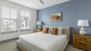 a bedroom with a white bed and a blue wall at Landing Apartments - Atlas Bluewood in Celina +38 photos