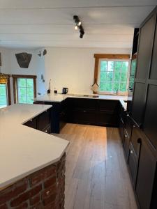 a kitchen with white counter tops and wooden floors at Haven Fortress in Kalven