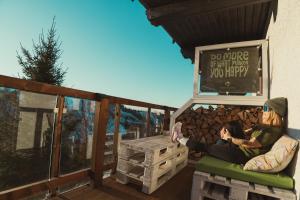 a woman sitting on a bench on a deck at Harz BnB Werkmeister in Sankt Andreasberg