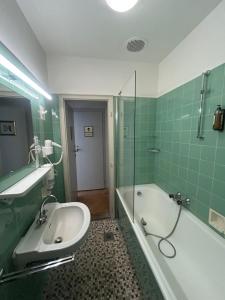 een badkamer met een bad en een wastafel en een ligbad bij the eighteen86 by keyone in Bad Gastein