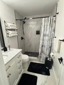 a white bathroom with a shower and a toilet at Private Studio with Patio-King Bed, Near Beach & Casinos in Hollywood +10 photos