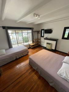 una camera da letto con due letti e una televisione di Hostal Valle Norte a Viña del Mar