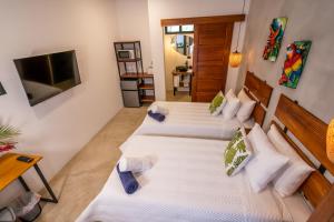2 aparte bedden in een kamer met een televisie bij Bahia Selvatica Lodge in Uvita