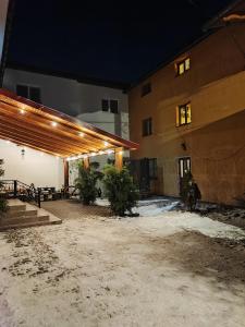 un edificio di notte con la neve sul terreno di Guest House Mandrivnyi Rooms&Apartments a Yasinia