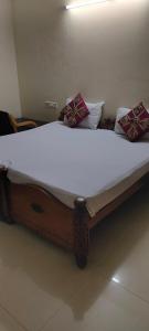 ein großes Bett mit weißen Laken und Kissen darauf in der Unterkunft Service Apartment at Brookefield in Bangalore
