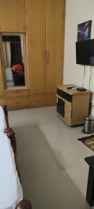 ein Zimmer mit einem Bett, einem Schreibtisch und einem Fernseher in der Unterkunft Service Apartment at Brookefield in Bangalore + 5 Fotos