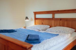 a bed with a wooden headboard and two pillows at Futterhaus neben der Wasserburg Liepen in Gielow
