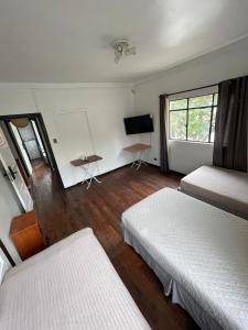 una camera con due letti e una TV a schermo piatto di Hostal Valle Norte a Viña del Mar Altre 40 foto