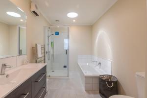 un bagno bianco con lavandino e doccia di Stylish apartment Whanganui a Whanganui Altre 24 foto