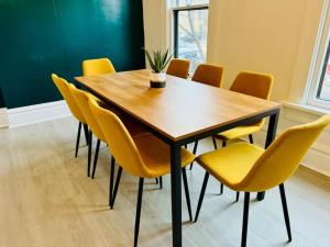 een conferentieruimte met een houten tafel en gele stoelen bij Jungle House Columbus Short North Downtown Free Parking - Near Convention Center & Nationwide Arena - 4BR Luxury Home - Sleeps 12 - Over 5,800 Five Star Stays in Columbus