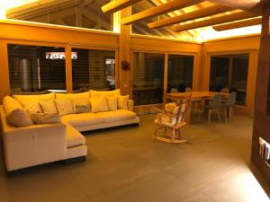 a living room with couches and a table with a dining room at Chalet Taulei tra Bormio e Livigno in Valdidentro