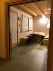 a room with a desk and a table and a glass door at Chalet Taulei tra Bormio e Livigno in Valdidentro