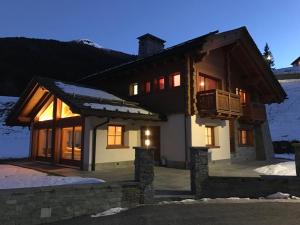 a house in the snow at night at Chalet Taulei tra Bormio e Livigno in Valdidentro