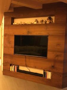 a flat screen tv on a wooden wall at Chalet Taulei tra Bormio e Livigno in Valdidentro