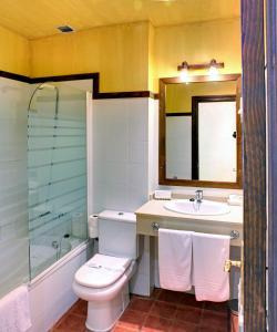 
a bathroom with a toilet a sink and a bathtub at Hotel Rural Coviella in Coviella
