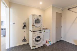 una lavanderia con lavatrice e lavatrice di Stylish apartment Whanganui a Whanganui