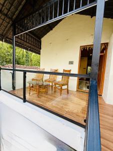 a balcony with chairs and a table on a house at Sanju Homestay in Chikmagalūr