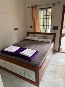 a bed in a room with a window at Sanju Homestay in Chikmagalūr