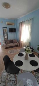 un soggiorno con tavolo, sedie e divano di Lia Apartment Sea View a Nea Fokea
