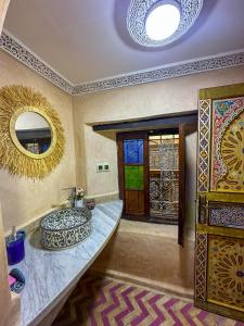a bathroom with a sink and a mirror at Riad Dar ElBellar in Fès
