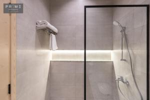 a bathroom with a shower and a bath tub with a shower at Prime Residence Zayed Heights in Sheikh Zayed