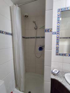 une salle de bain avec douche et lavabo dans l'établissement casa na aldeia - entre Fundão e Covilhã, à Pêro Viseu