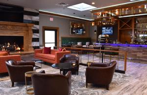 a lobby with a bar with couches and a fireplace at The Fontana Hotel in Indianapolis