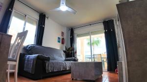 ein Wohnzimmer mit einer Couch und einem Deckenventilator in der Unterkunft Apartalux Vera Palace in Vera