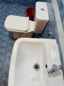 a bathroom with a white sink and a toilet at Tha Villa Calangute in Calangute +3 photos
