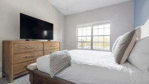 ein Schlafzimmer mit einem Bett und einem Flachbildfernseher in der Unterkunft Landing Stunning 2BD Tennis Court Pool in McDonough + 34 Fotos