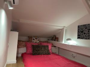 een slaapkamer met een bed met roze lakens en kussens bij Casa Favelas, Vue Mer, plages et Monaco à pieds in Cap d'Ail