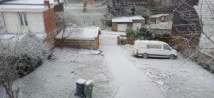 een bestelwagen geparkeerd op een erf met sneeuw op de grond bij Belle CHAMBRE in Seraing