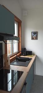 eine Küche mit einer Theke und einem Herd Oberer Backofen in der Unterkunft Maison de vacances Ile d'Oléron 2 Chambres in Saint-Pierre-dʼOléron + 3 Fotos