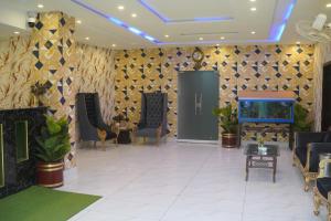 a lobby with chairs and a fish tank on a wall at Hotel Shanze Palace in Lahore +65 photos