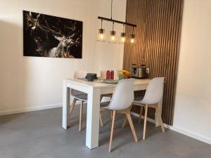 een eetkamer met een witte tafel en stoelen bij Platzhirsch-bei-der-Purpurbuche in Bad Harzburg