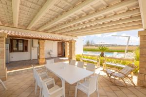 un patio esterno con tavolo e sedie bianchi di Villa Mare Salento a Taurisano