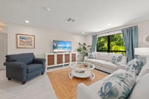 萨尼贝尔Ground Floor Luxury - Your choice of 2 Bikes or Kayak Rental - Steps to Beach!的客厅里有一张沙发和一张桌子。