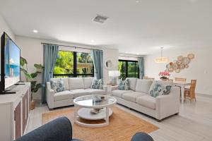 een woonkamer met twee banken en een tafel bij Ground Floor Luxury - Your choice of 2 Bikes or Kayak Rental - Steps to Beach! in Sanibel