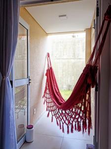 eine Hängematte, die von einem Fenster in einem Zimmer hängt in der Unterkunft Refúgio com lazer completo em Pium RN in Parnamirim