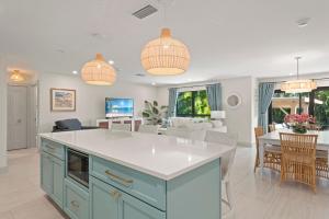 een keuken met blauwe kasten en een woonkamer bij Ground Floor Luxury - Your choice of 2 Bikes or Kayak Rental - Steps to Beach! in Sanibel