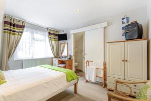 a bedroom with a bed and a television in it at Capritia Guest House in Dartmouth