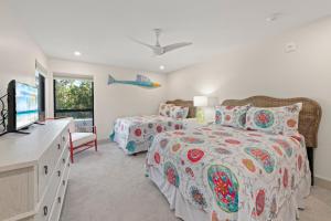 een slaapkamer met twee bedden en een flatscreen-tv bij Ground Floor Luxury - Your choice of 2 Bikes or Kayak Rental - Steps to Beach! in Sanibel +47 foto's