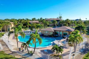 een luchtzicht op een zwembad van het resort met palmbomen bij Ground Floor Luxury - Your choice of 2 Bikes or Kayak Rental - Steps to Beach! in Sanibel