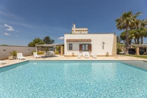 una villa con piscina di fronte a una casa di Villa Mare Salento a Taurisano