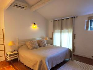 een slaapkamer met een groot bed en een raam bij Maison d'hôte Mas de Castille entre Uzès et le pont du Gard in Argilliers