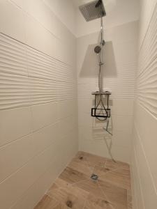 un bagno con doccia e piastrelle bianche di Kercabellec a Mesquer