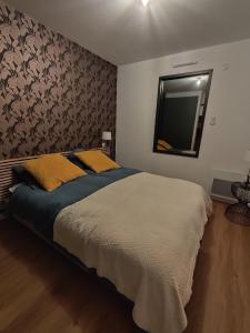 una camera da letto con un letto grande e uno specchio di Kercabellec a Mesquer