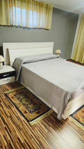 ein Schlafzimmer mit großem Bett und Holzboden in der Unterkunft Casa Sulfina in Radoşi