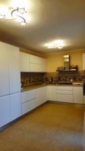 eine große Küche mit weißen Schränken und einer Decke in der Unterkunft Casa Sulfina in Radoşi